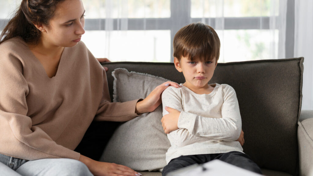 Mamma appoggia la mano sulla spalla al figlio arrabbiato