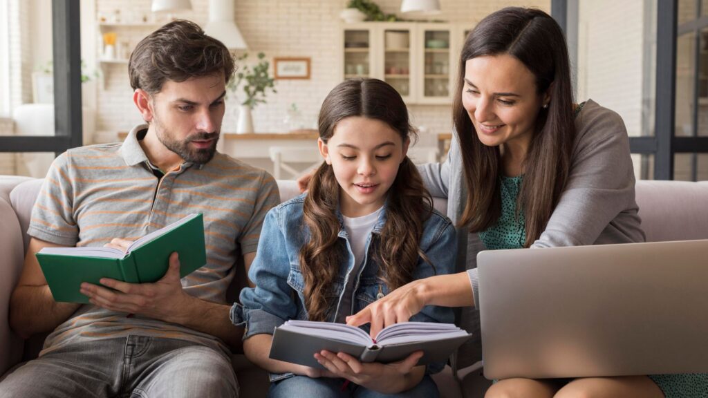 Mamma e papà fanno i compiti sul divano insieme alla figlia